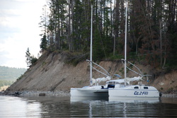 catamaran sailboat anchored near woods