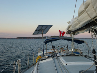 140 watt rigid solar panel mounted to top of pole on stern 32 foot sailboat