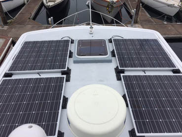 4 rigid marine solar panels mounted to roof of boat