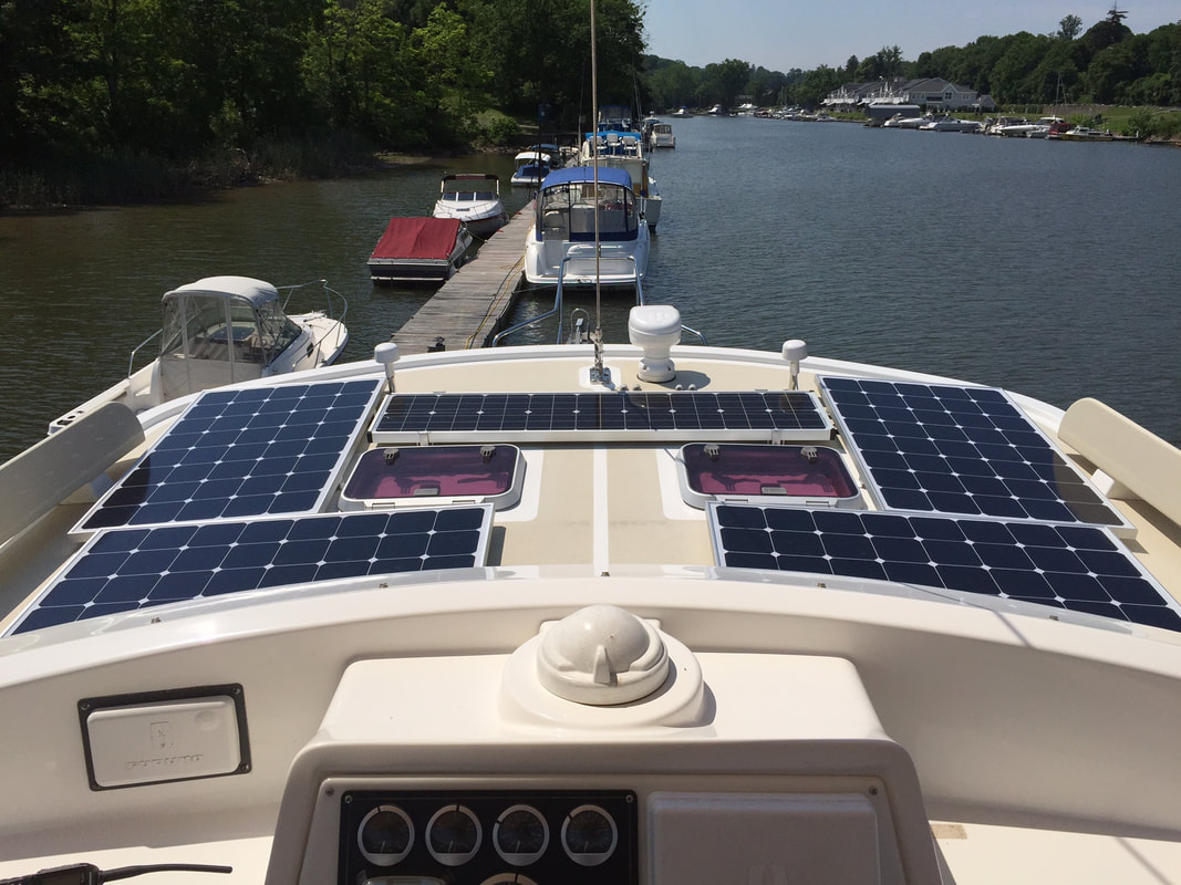Two 100 watt flexible marine solar panels, Two 120 Watt SunPower cell marine solar panels and a narrow Fifth solar Panel on a Kayde-Krogen boat